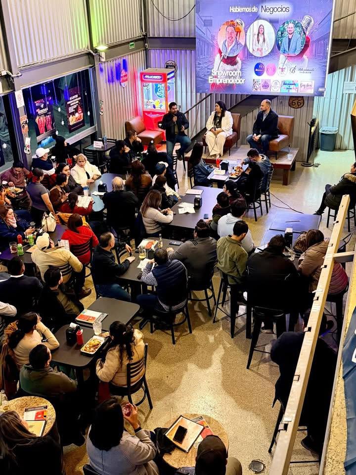 Conversación entre tres participantes al frente de un encuentro con emprendedores